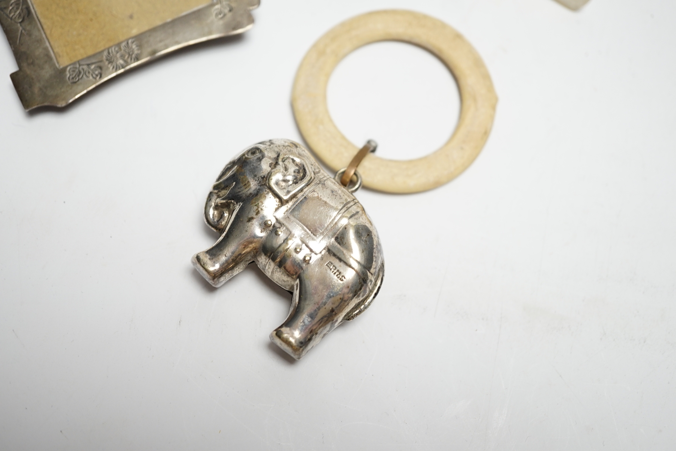 An Edwardian silver and mother of pearl child's rattle, 11cm, together with a miniature white metal photograph frame and a plated child's rattle.